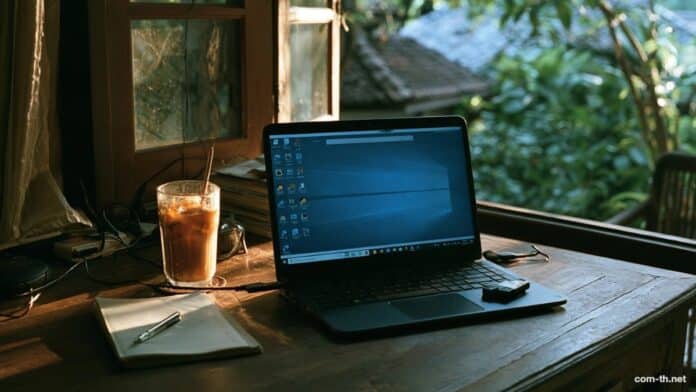 โน้ตบุ๊กบนโต๊ะทำงานในบ้าน พร้อมแฟลชไดรฟ์สำหรับติดตั้ง Windows 11